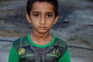 Sad boy in a refugee camp with sad face for lost family